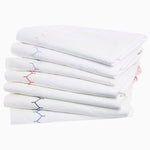A stack of Stitched Ink Organic Sheets with blue and red stitching, featuring embroidered designs by John Robshaw. - 30446587674670