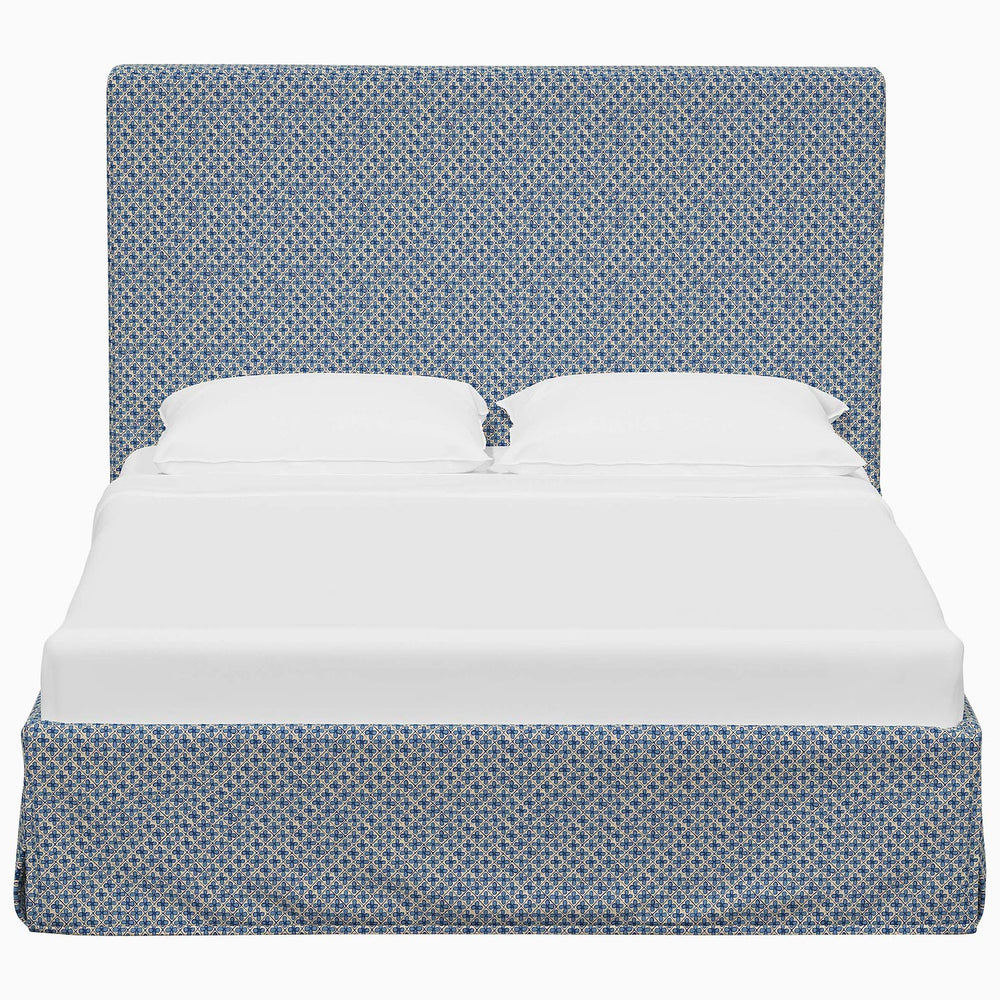 A Shona Bed by John Robshaw with a blue and white patterned cover made from fabrics.