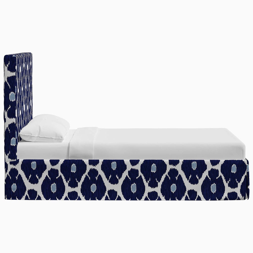A Shona Bed with a blue and white patterned headboard featuring prints by John Robshaw.