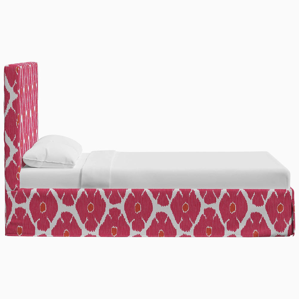 A Shona Bed with a pink and white patterned headboard made of John Robshaw prints.