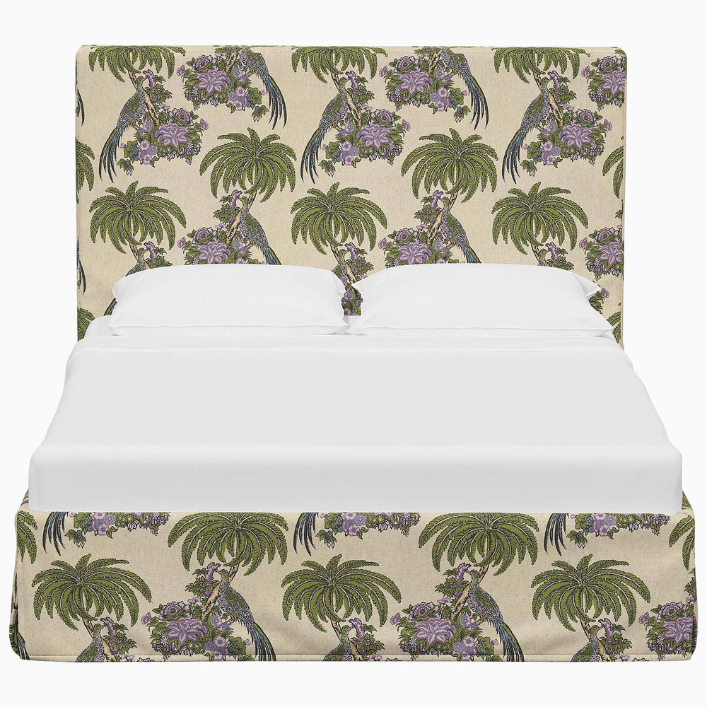 A John Robshaw Shona-style printed bed adorned with fabrics featuring palm trees and flowers.