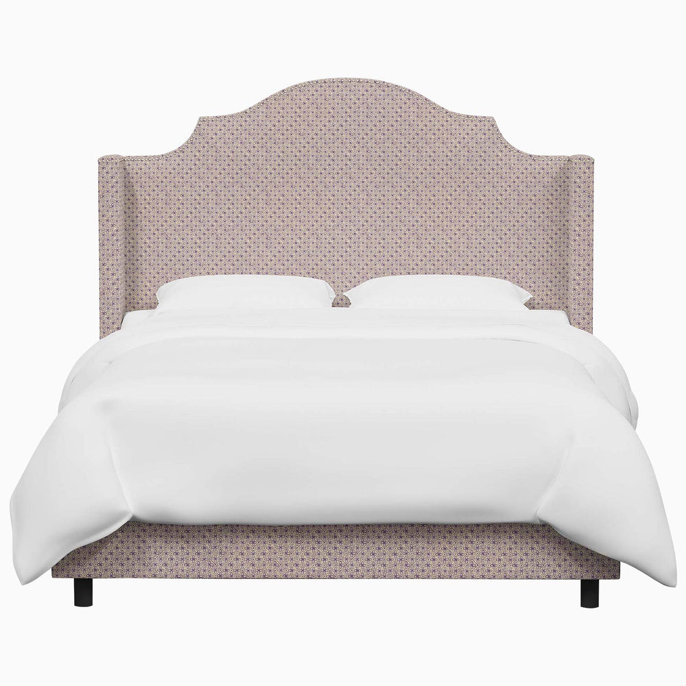 The John Robshaw Samrina bed features a pink upholstered headboard, adding a touch of elegance to the white bed.