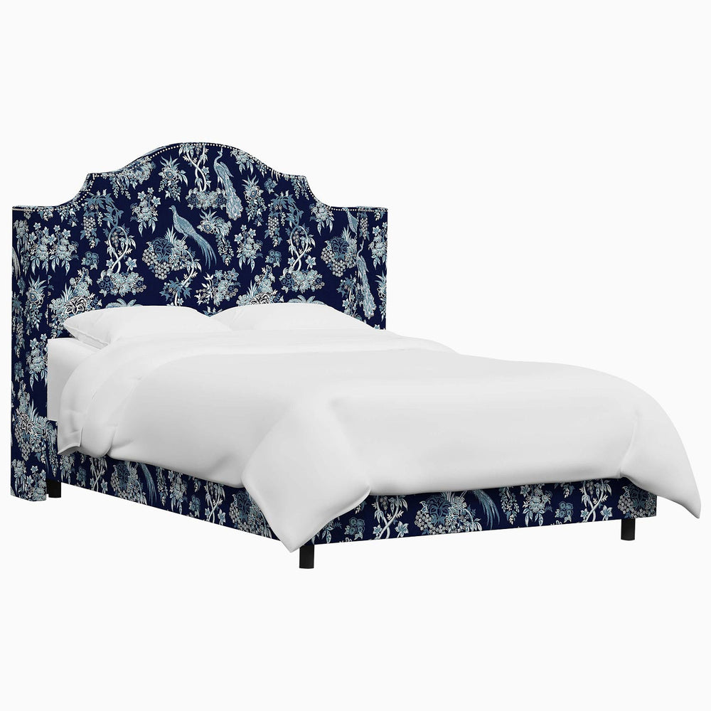 The John Robshaw Samrina bed features a blue floral upholstered headboard, adding a touch of elegance to any bedroom.