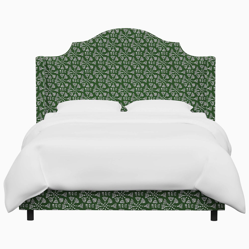 A green upholstered John Robshaw Samrina bed with a white headboard.