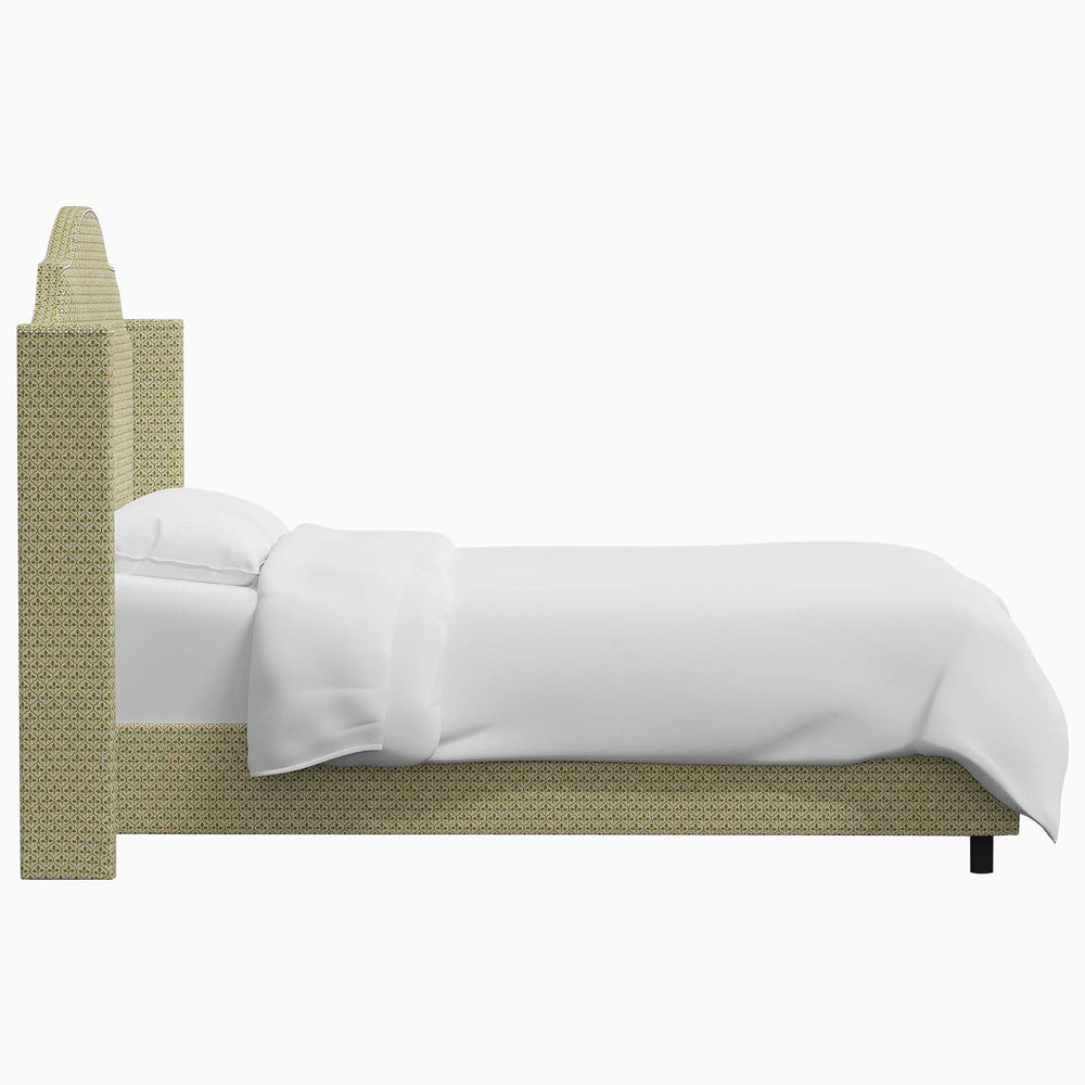 The John Robshaw Samrina bed features a white sheet elegantly draped over its soft surface, accompanied by a stylish beige headboard.