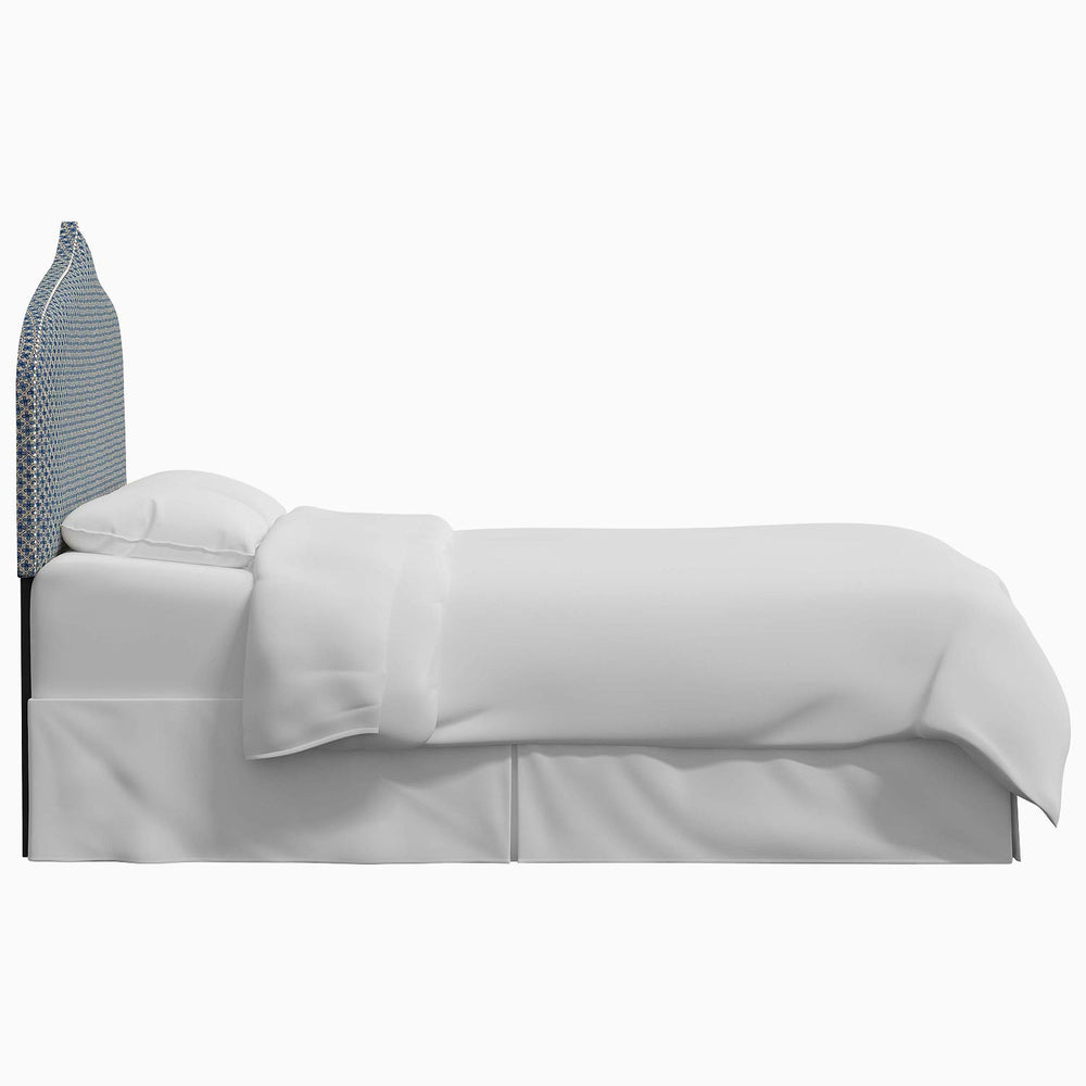 A white bed with a blue John Robshaw Alina Headboard.