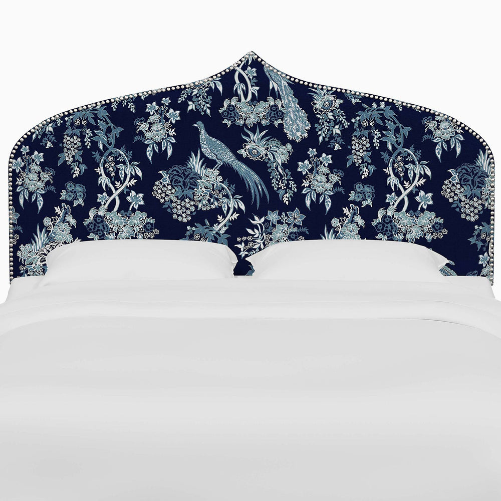 A bed with an Alina Headboard adorned with Mughal arches and intricate prints from John Robshaw.