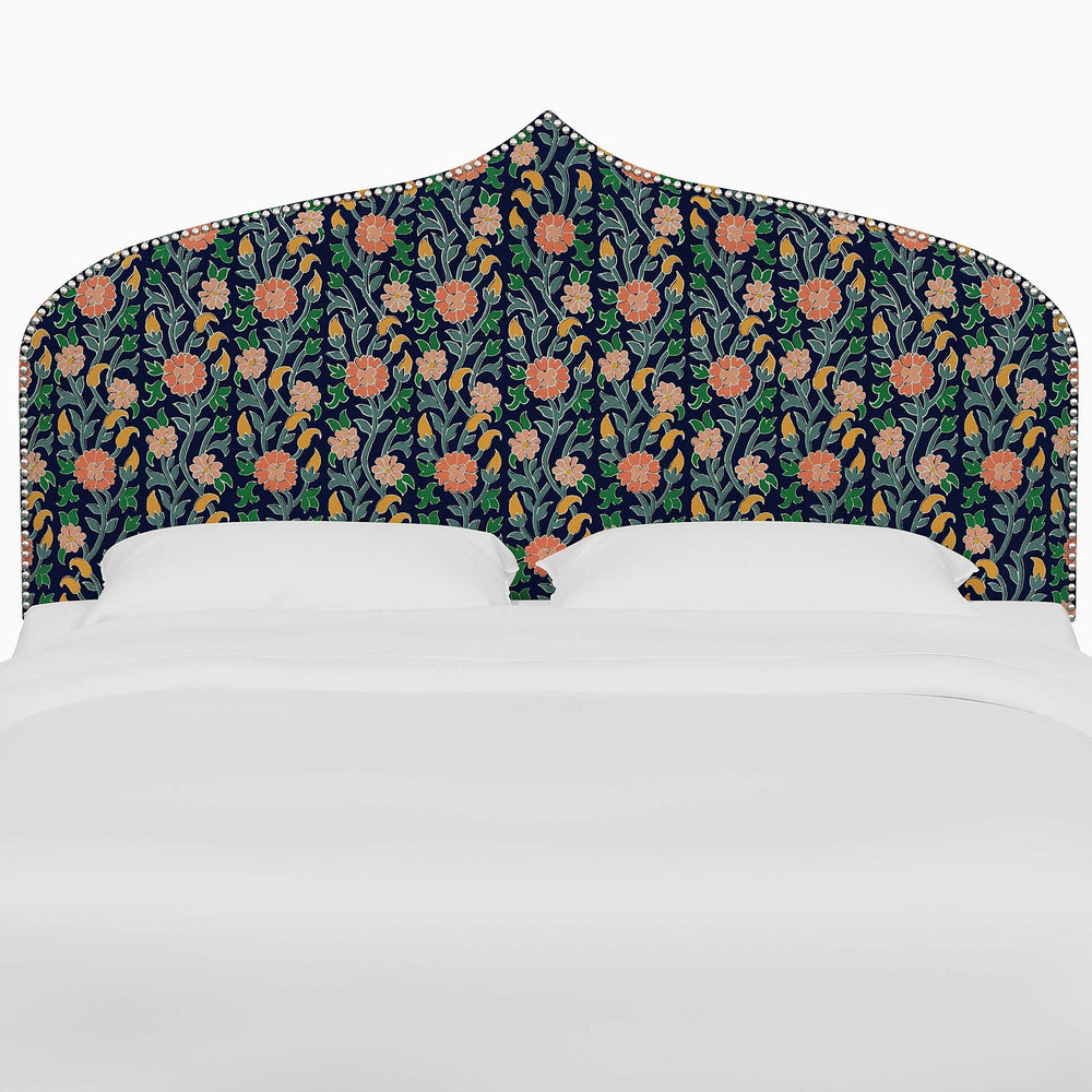 A bed with floral prints on the John Robshaw Alina Headboard.