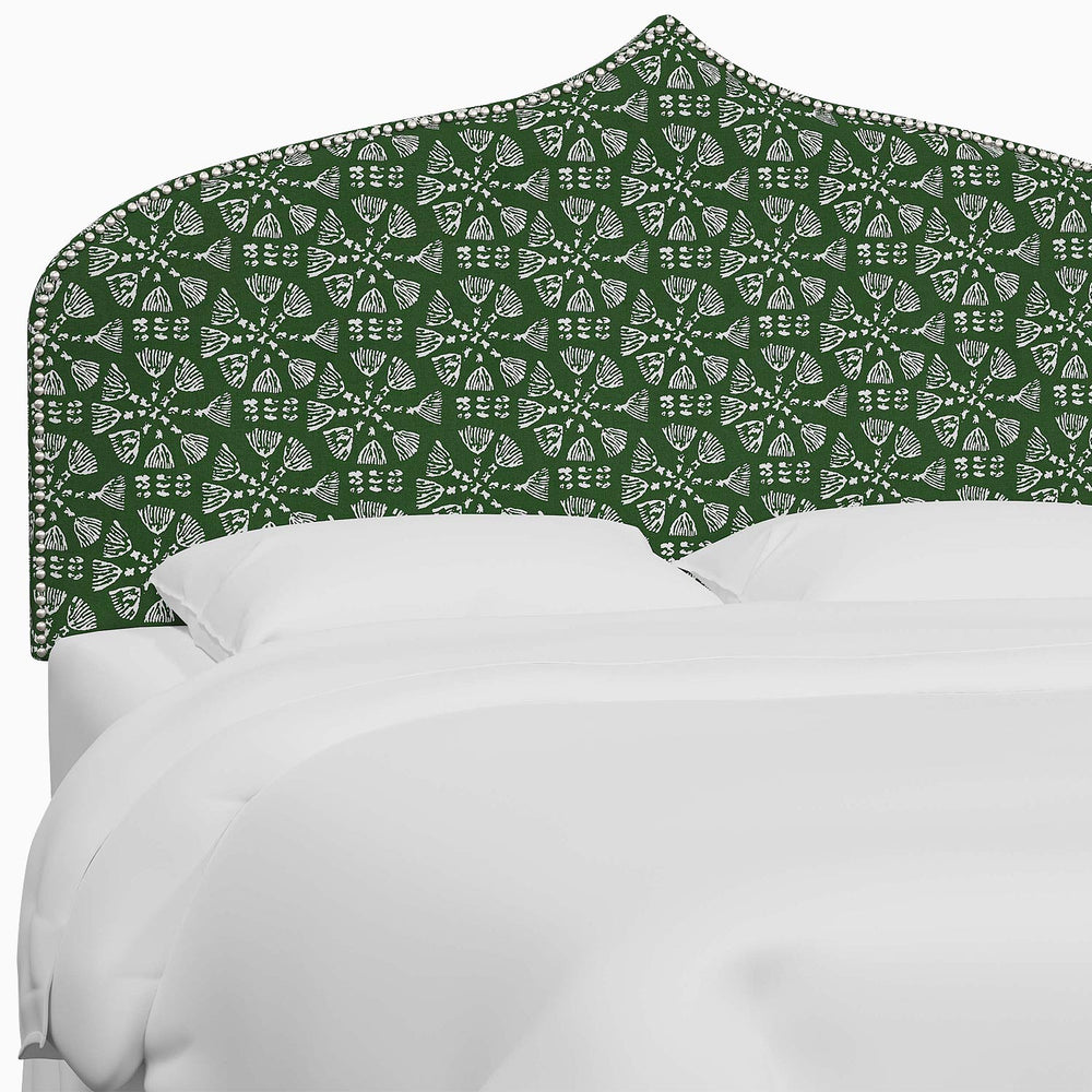 A bed with a green and white patterned Alina headboard featuring Mughal arches by John Robshaw.