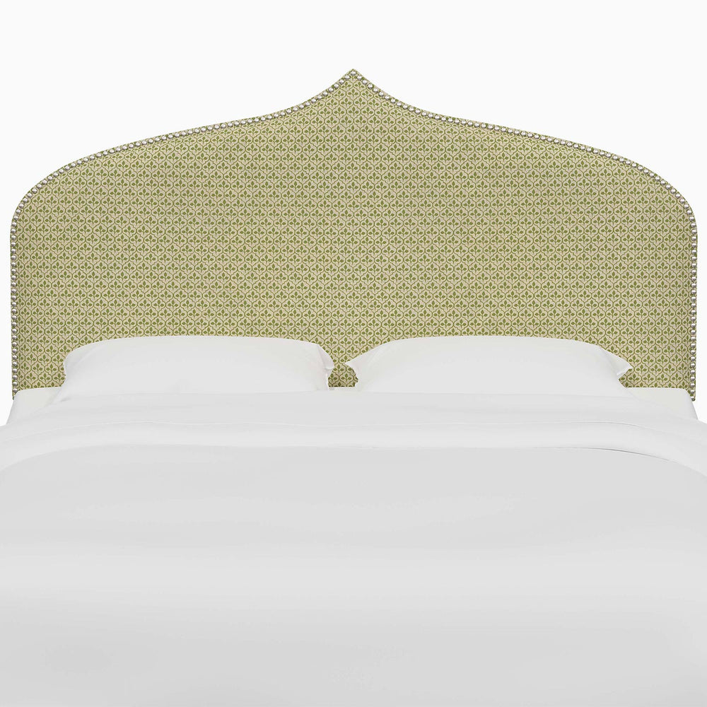 A bed with a green John Robshaw Alina headboard and white sheets.