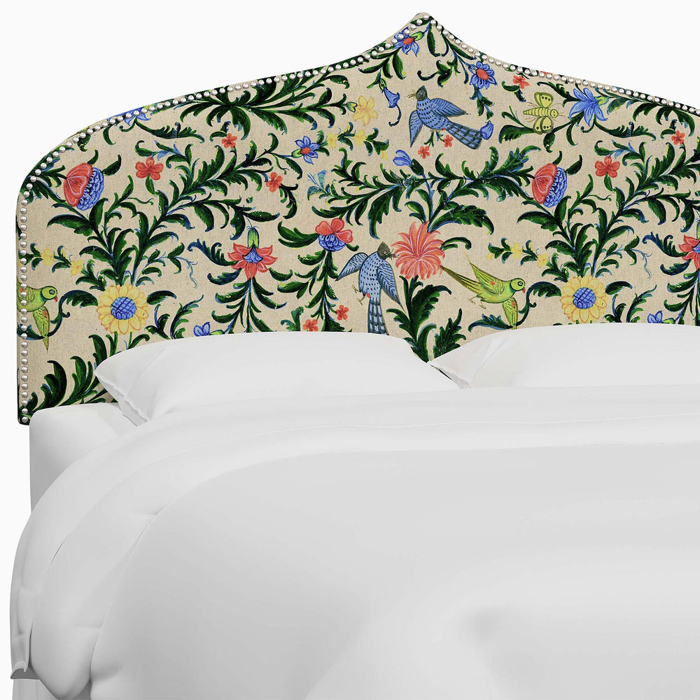 A bed with a colorful floral Alina Headboard featuring Mughal arches and John Robshaw prints.