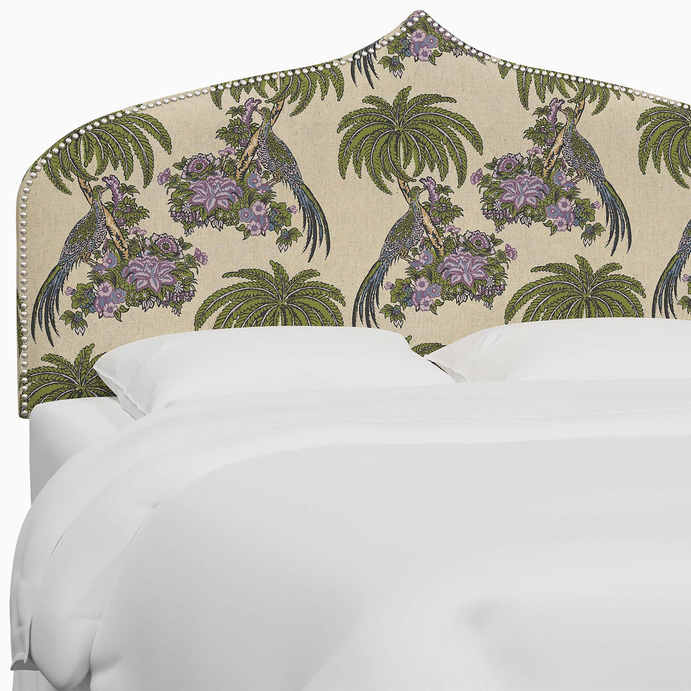 A bed with an Alina Headboard from John Robshaw, featuring a purple and green bird print headboard with Mughal arches.