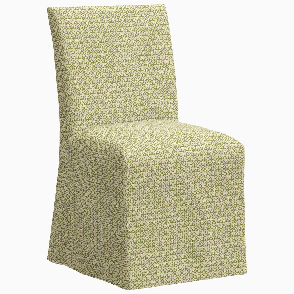The Skyline Sadia Slipcover Chair is a stylish dining chair featuring a green patterned upholstered seat.