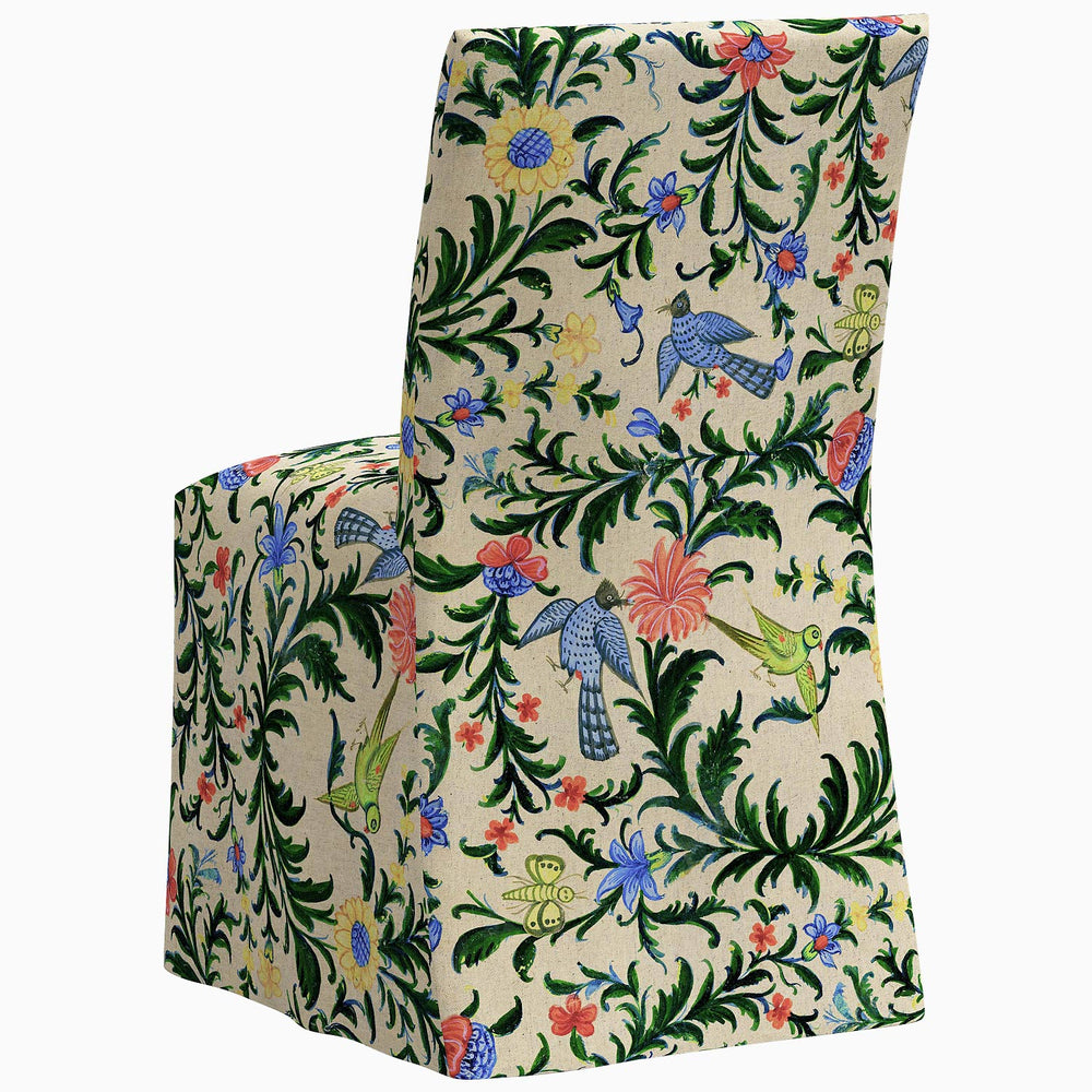 The John Robshaw Sadia Slipcover Chair, a stylish dining chair, features a beautiful floral pattern on its slipcover.