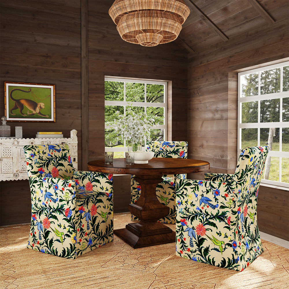 A dining room with a wooden table and John Robshaw Rekha Slipcover Dining Chairs in exclusive prints.