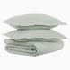 A stack of John Robshaw's Cinde Sage Organic Duvet pillows on top of each other.