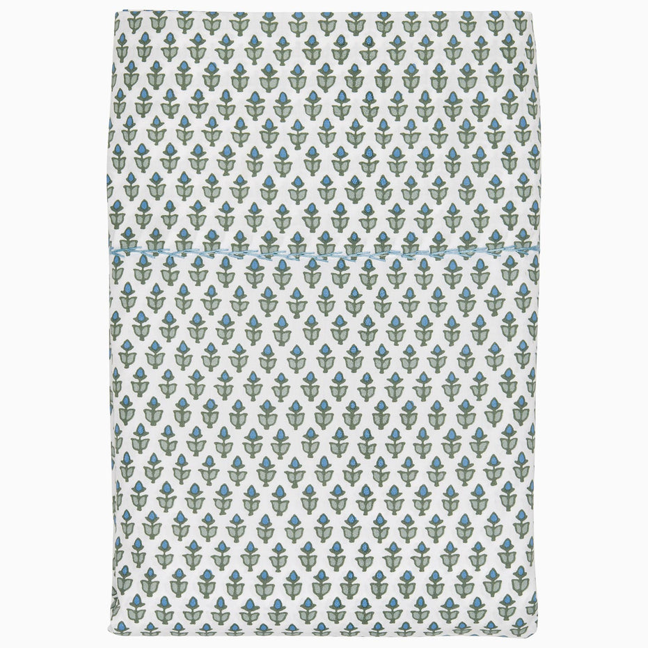 A white and blue blanket with a floral pattern made of Cala Sage Organic Sheets by John Robshaw.