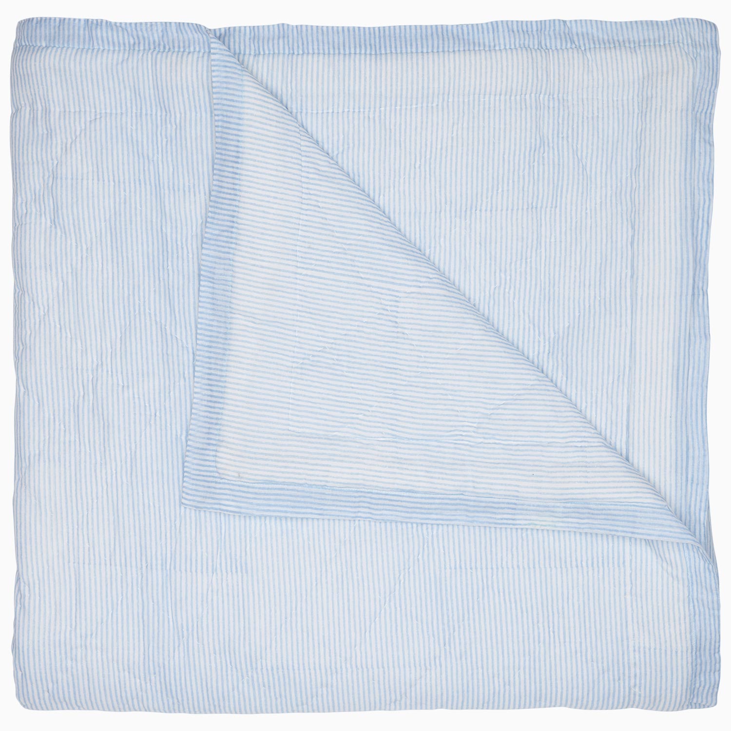 A Nandi Light Indigo quilt by John Robshaw with blue and white striped block printing on a white background.