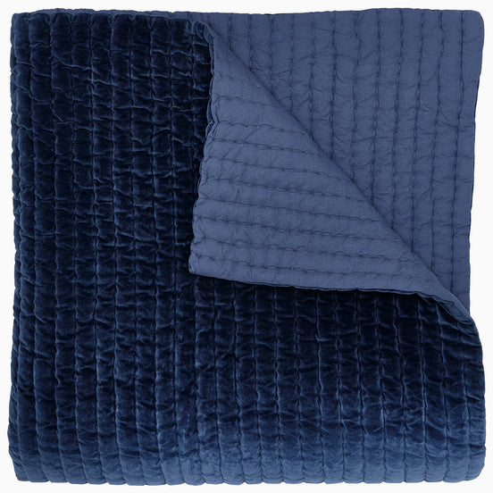 A John Robshaw Velvet Indigo Quilt on a white background.