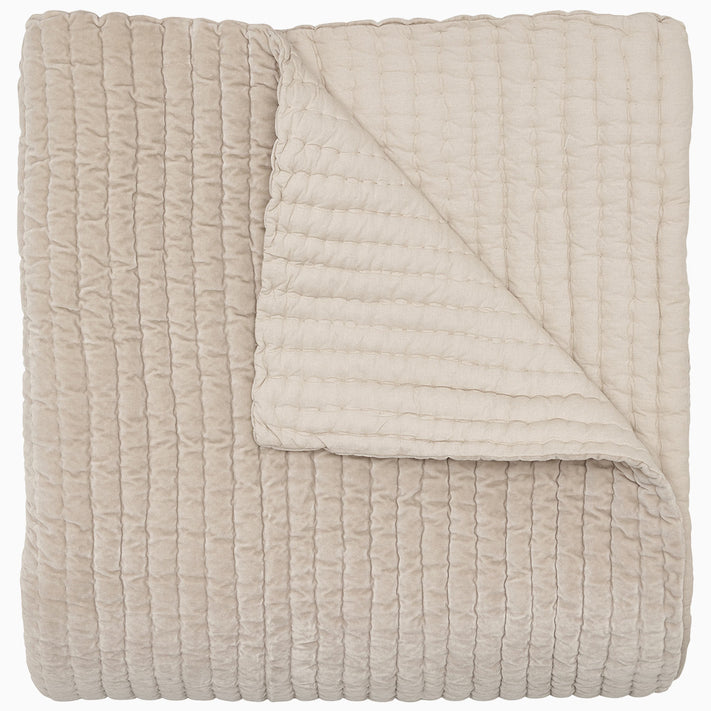 A soft, beige Velvet Sand Quilt by John Robshaw on a white background.