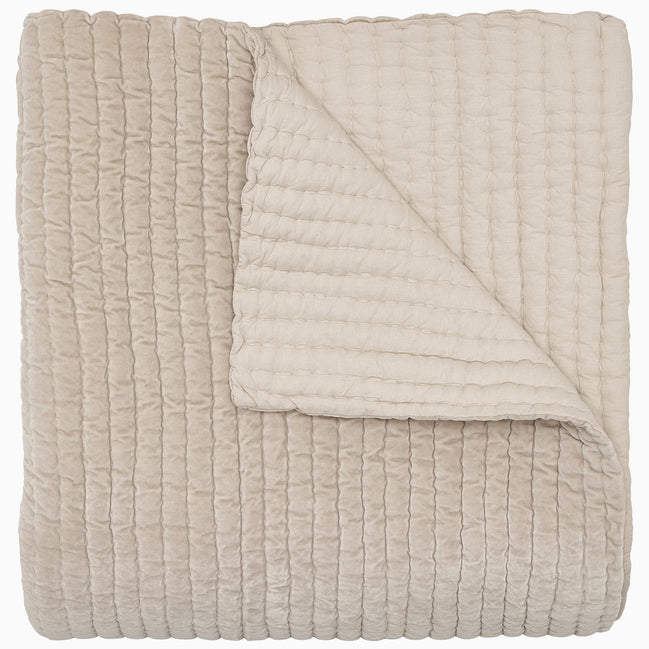 A soft, beige Velvet Sand Quilt by John Robshaw on a white background.