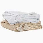 Two Chahan Ivory Throw towels with tassels stacked on top of each other. - 30783883935790