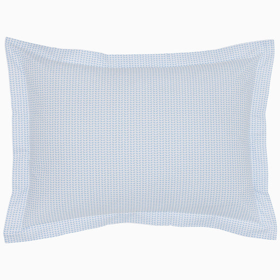 The Cinde Light Indigo Organic Duvet by John Robshaw is a rectangular pillow with a light blue and white patterned cover, featuring a 200 thread count percale with small repeated designs and a flanged edge.