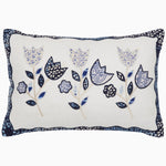 The Upcycled Tulips Kidney Pillow by John Robshaw is a rectangular decorative pillow with a white background, showcasing an embroidered design of blue and black floral patterns. Crafted from cotton linen, the pillow also features a blue and black patterned border. - 31272650670126