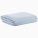 The Cinde Light Indigo Organic Duvet by John Robshaw, folded neatly on a white surface with its textured knit pattern, complements any décor alongside your stylized print bedding.