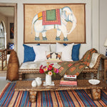 A vintage living room adorned with a hand-painted White Elephant on Cream Tapestry mural, reminiscent of traveling in India by John Robshaw. - 30720448462894