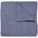 A Vivada Indigo Woven Quilt by John Robshaw folded on top of itself.