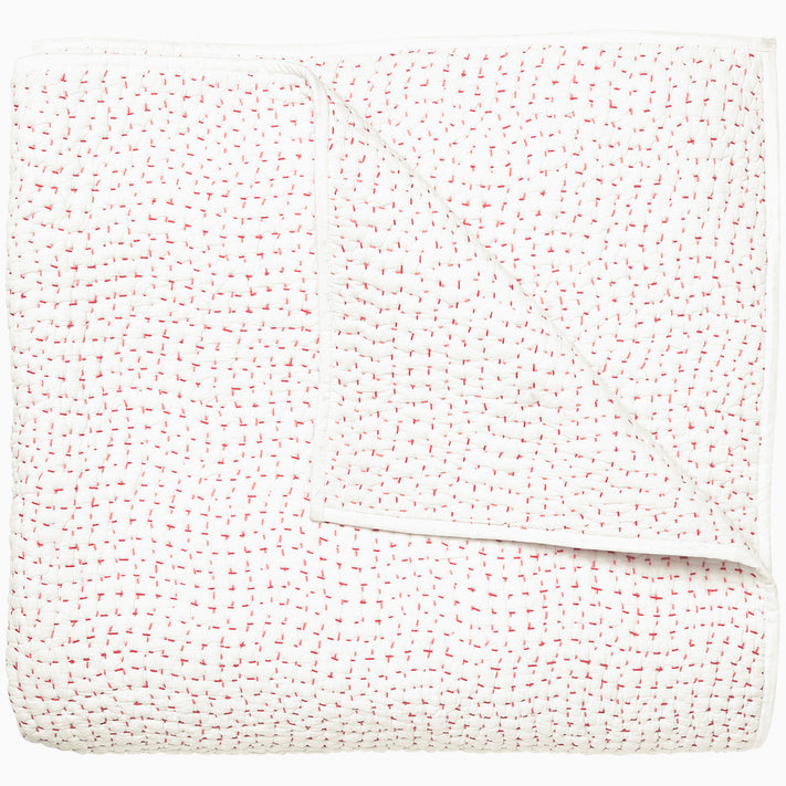 A white and pink Organic Hand Stitched Lotus Quilt with dots, by John Robshaw.