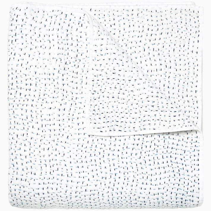A white Organic Hand Stitched Light Indigo Quilt with blue dots on it, made with hand stitching and cotton voile, by John Robshaw.