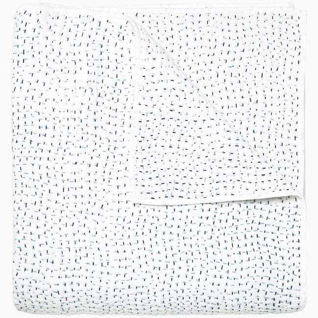 A white Organic Hand Stitched Light Indigo Quilt with blue dots on it, made with hand stitching and cotton voile, by John Robshaw.
