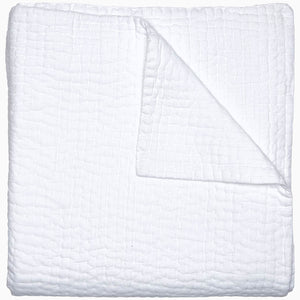 A Vivada White Woven Quilt by John Robshaw folded on top of a white surface with hand stitching.