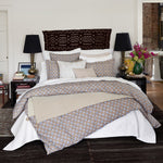 A bedroom with a bed and a John Robshaw Stitched Sand Organic Sheets collection. - 29299684016174