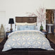A bedroom with a blue and white comforter featuring a John Robshaw Cinde Light Indigo Organic Sheet Set made from 100% cotton percale.