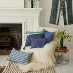 A Dip Dyed Indigo Decorative Pillow by John Robshaw in front of a fireplace. - 29372009447470