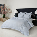 A blue and white bedroom with a Ramra Indigo Organic Duvet by John Robshaw and a lamp. - 29300122779694