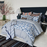 This blue and white bedroom features a Ramra Indigo Organic Sheets duvet on a cozy bed, adorned with John Robshaw organic cotton percale pillows. - 29299679068206