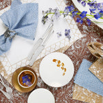 A table setting with John Robshaw's hand-stitched cotton slub napkins and flowers. - 29333350088750