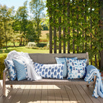 A Nilay Indigo Outdoor Bolster by John Robshaw on a wooden deck. - 30009673744430