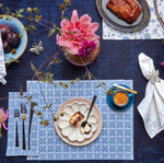 A blue and white table setting with flowers, fruit, and John Robshaw's Pavati Periwinkle Napkins (Set of 4). - 30009668763694