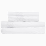 Three Sana White Organic Sheet Sets, made by Sheets & Cases, stacked on top of each other. - 28739485138990