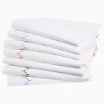 A stack of John Robshaw Stitched Blush Organic Sheets with embroidered designs featuring blue and red stitching. - 28739511648302