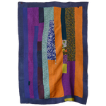 A vibrant quilt with Orange Up colors hanging on a wall, by John Robshaw. - 12783881125934