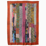 A vibrant patchwork quilt in Washy Pink by John Robshaw, made from soft cotton, reminiscent of the intricate quilting tradition of India, elegantly adorns a wall. - 30253766869038