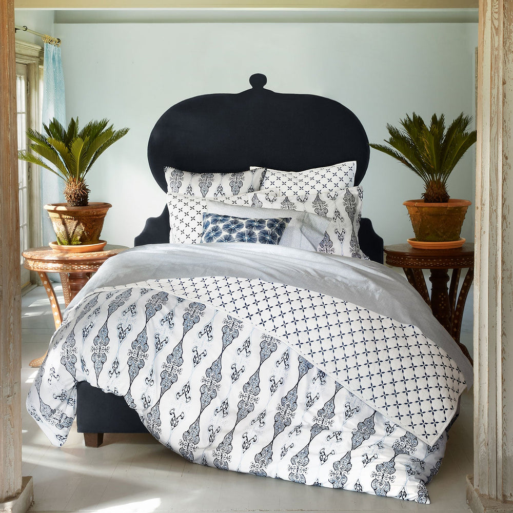 A John Robshaw Custom Orissa Bed in a bedroom with a blue and white pattern, available for shipping.