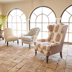 Three Saanya Berry armchairs by John Robshaw sitting on a brick floor in a room. - 30262777741358