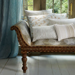 An antique Chand Clay Daybed upholstered with pillows in front of a window. - 29020418867246